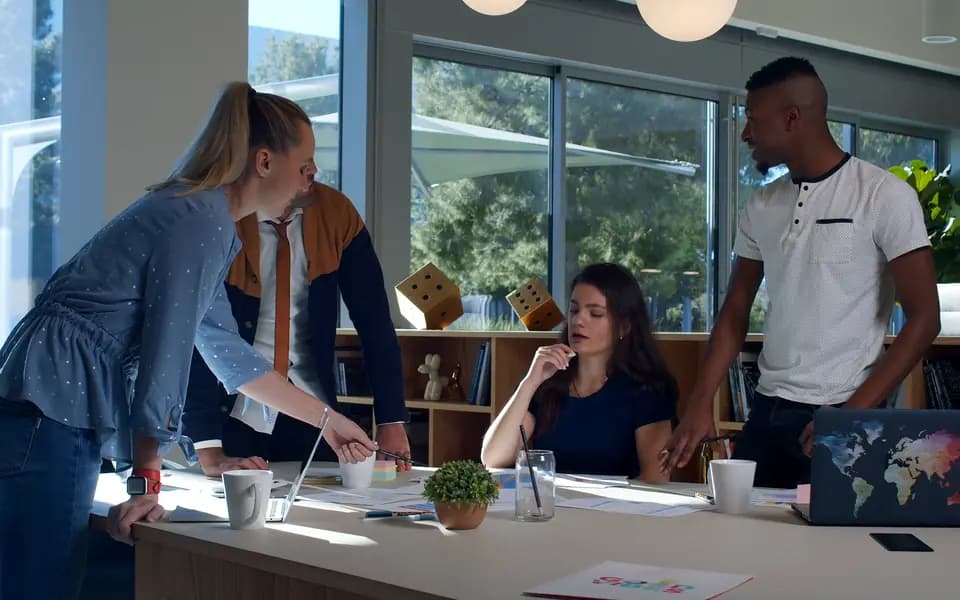 A small team planning a project around a desk