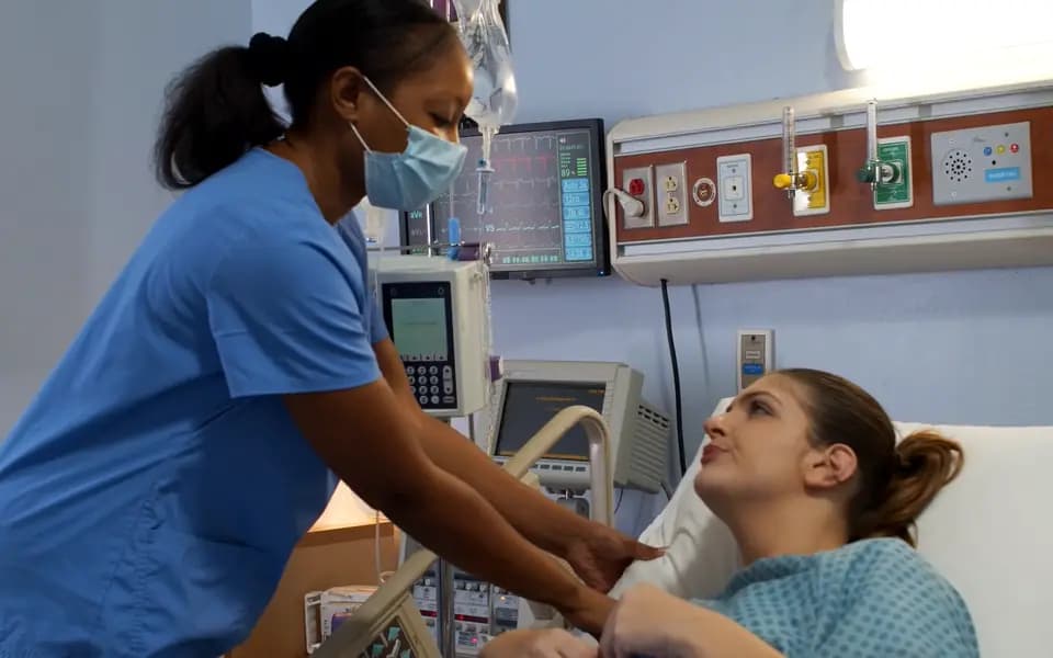 A nurse caring for a patient on a hospital ward